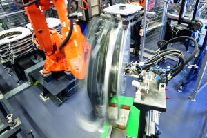Roboter mit schnell drehender Montagehilfe beim Auftragen des Klebstoffes auf die in der Montagehilfe eingelegten Magnetschalen. (Bild: Thyssenkrupp AG)